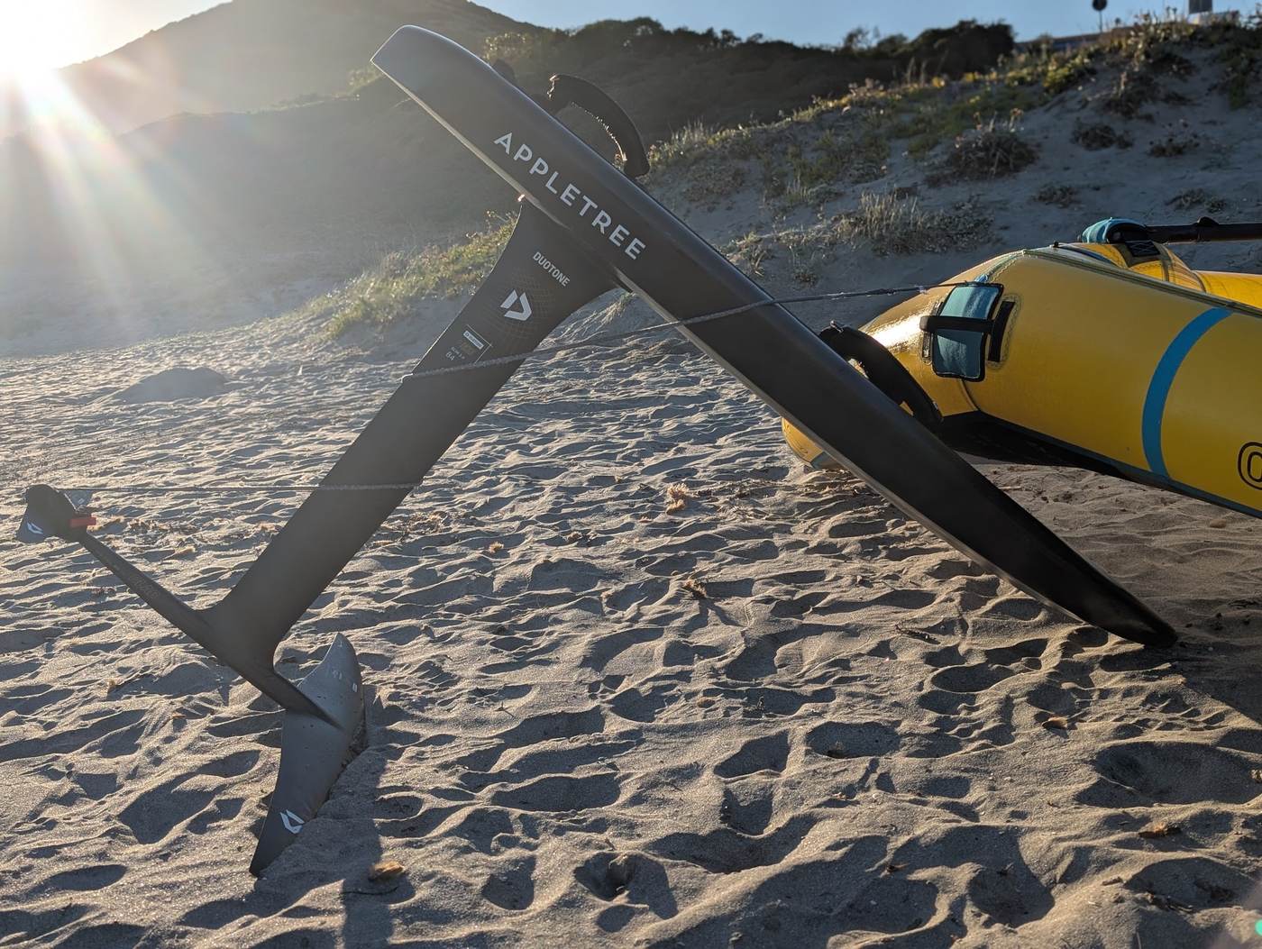 Wingfoil-Ausrüstung am Strand in den Dünen bei Sonnenuntergang