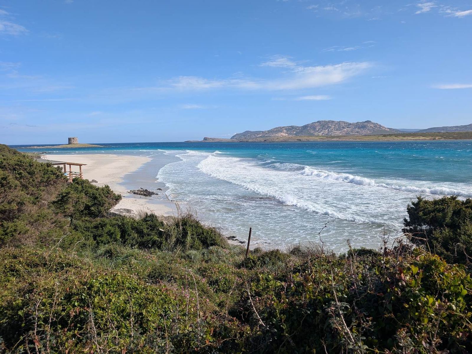 Türkisfarbene Bucht mit weißem Sandstrand und Wachturm, Sardinien